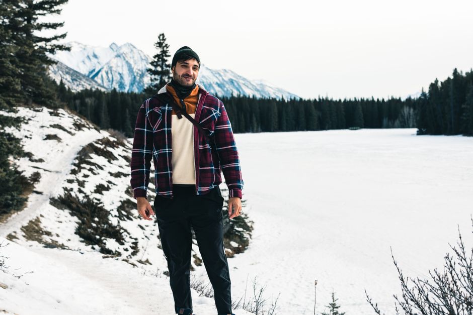 A man poses smiling in the snowy landscape of Banff National Park, Canada.