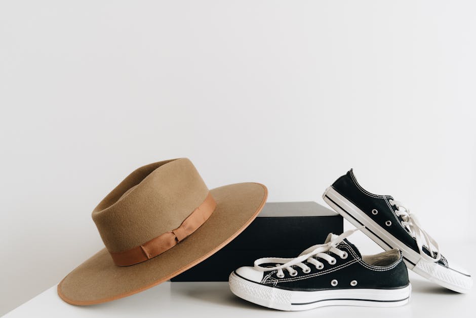 Minimalist display of a fedora and sneakers on a white background, perfect for fashion enthusiasts.