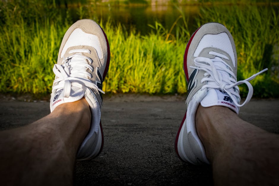 A person enjoys a quiet moment outdoors wearing sneakers against a green backdrop.