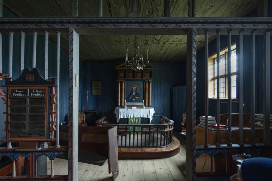 A beautifully preserved historic church interior featuring an altar and painted artwork.