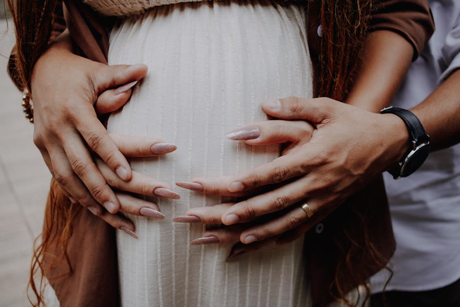 Intimate close-up of hands embracing a pregnant belly, symbolizing love and family bonds.