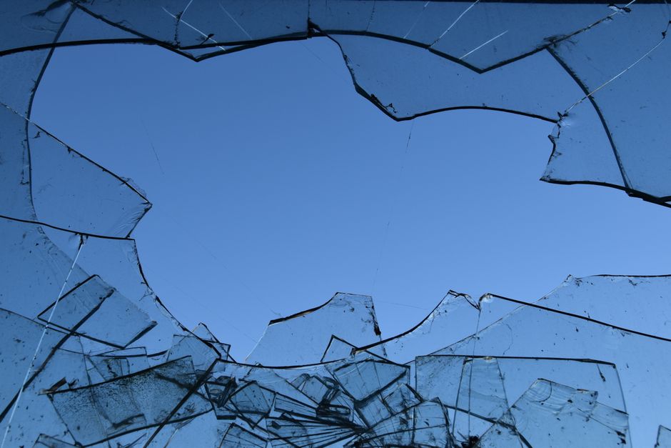 Dramatic image of shattered glass set against a vivid blue sky, captured in Hamburg.