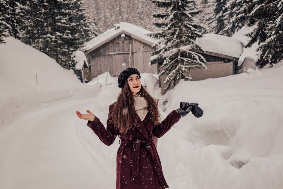 Stylish woman in snowy outdoor setting, embracing winter fashion.