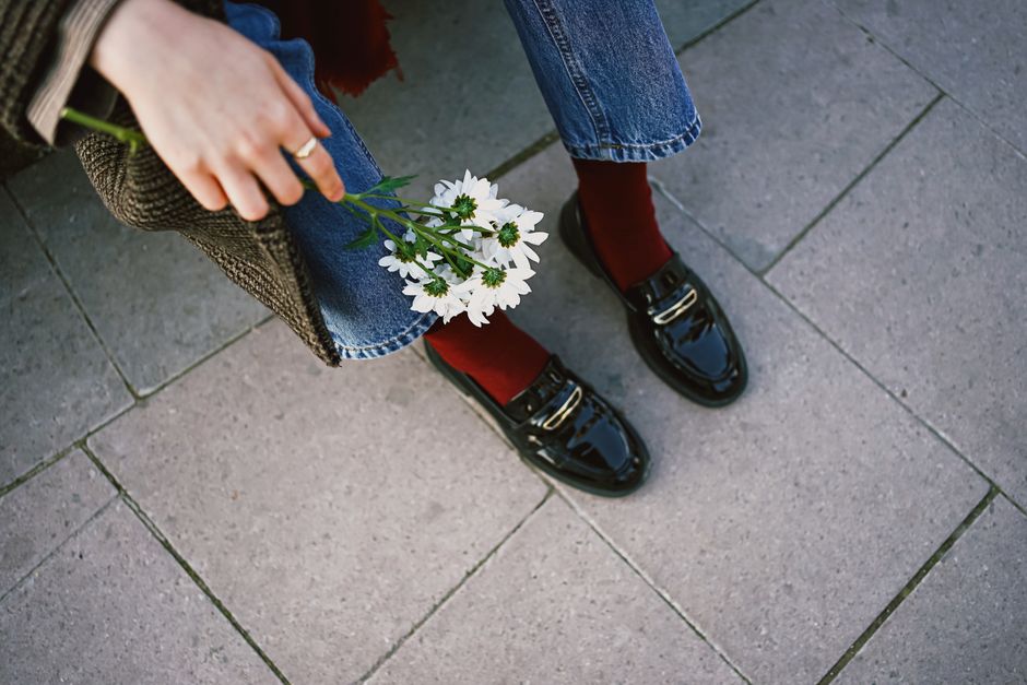 Stylish outfit with polished shoes, jeans, and daisies for a chic casual look.